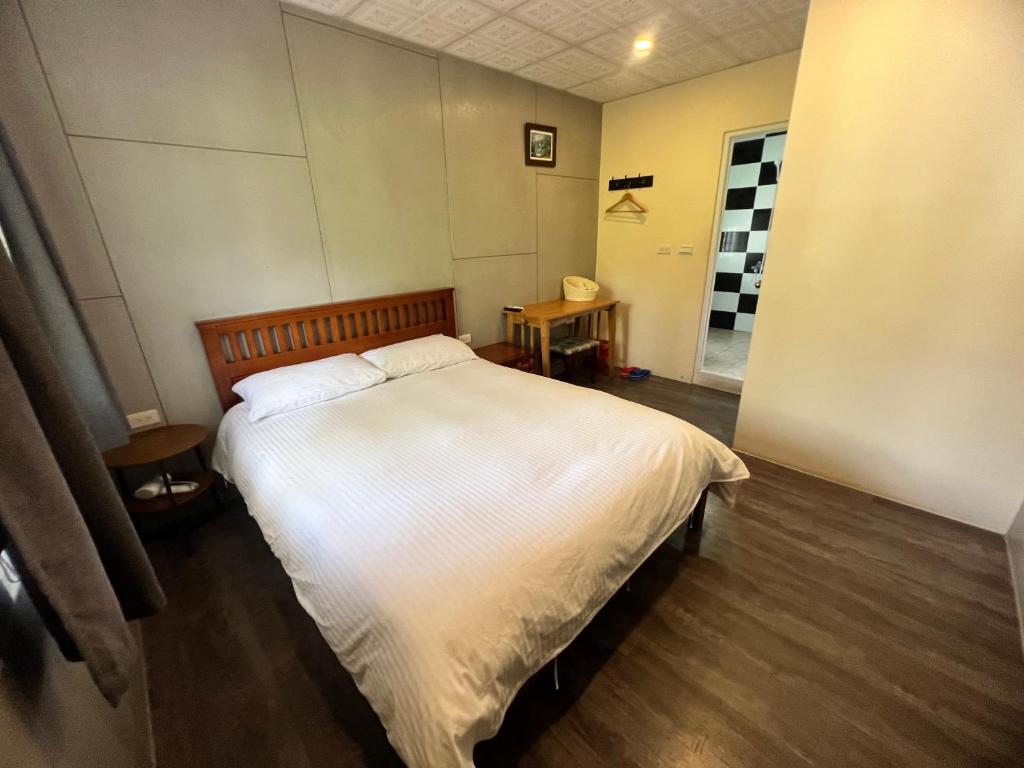 a bedroom with a large bed with white sheets at Golden flower Homestay in Yuli