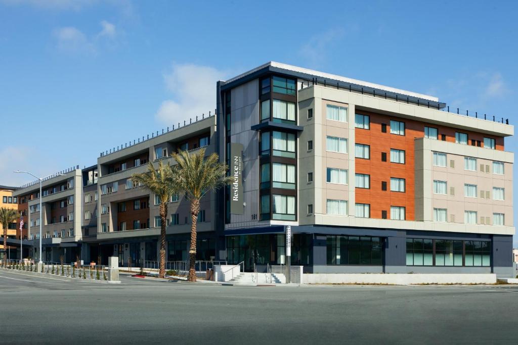 Residence Inn by Marriott San Francisco Airport Millbrae Station في ميلبراي: مبنى كبير أمامه نخلة