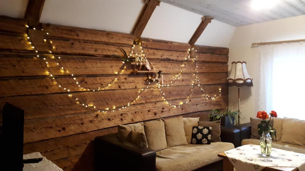 a living room with a wooden wall with christmas lights at Mulgi Apartment in Viljandi