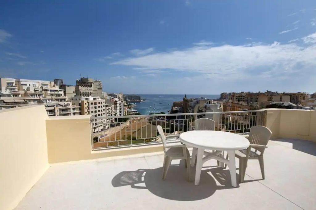 a table and chairs on a balcony with a view at Seaview Penthouse Balluta Bay VC in St Julian's