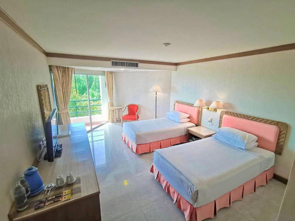 Habitación de hotel con 2 camas y TV en Khanom Golden Beach Hotel en Khanom