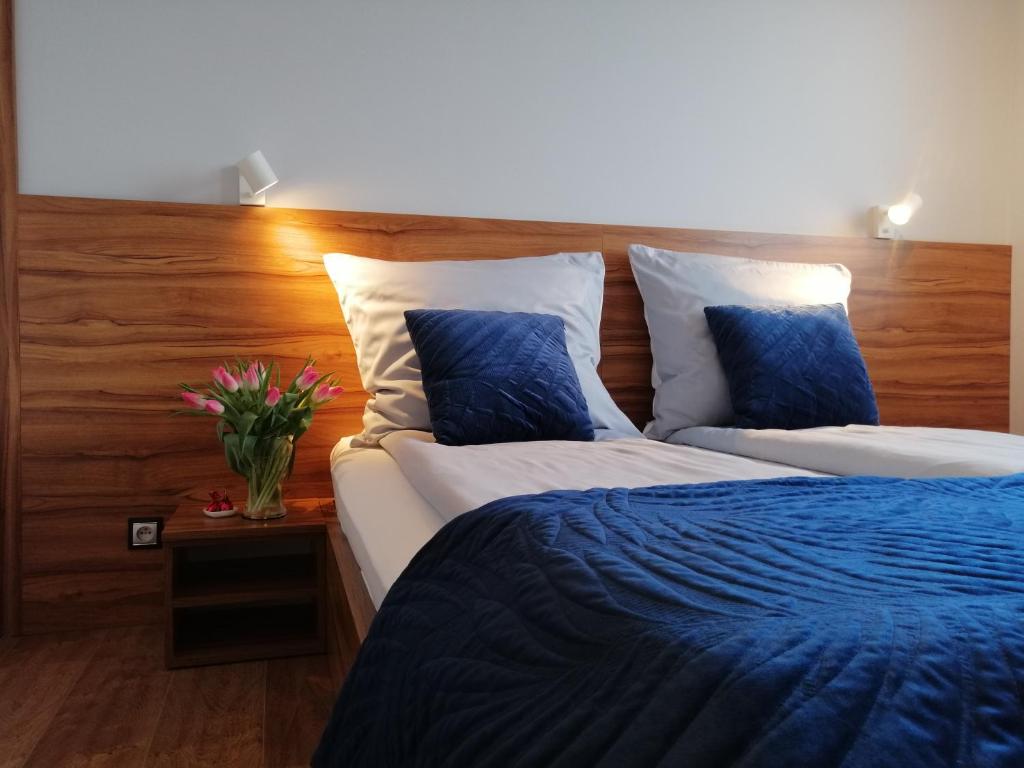 1 dormitorio con 1 cama con sábanas y almohadas azules en Apartament71, en Płock