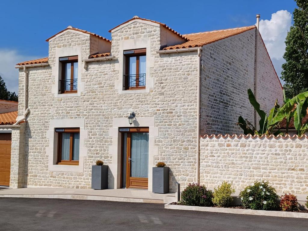 una casa con una fachada de piedra en La Grange 3 étoiles - Maison d'hôte à 10 min des plages, en Thairé
