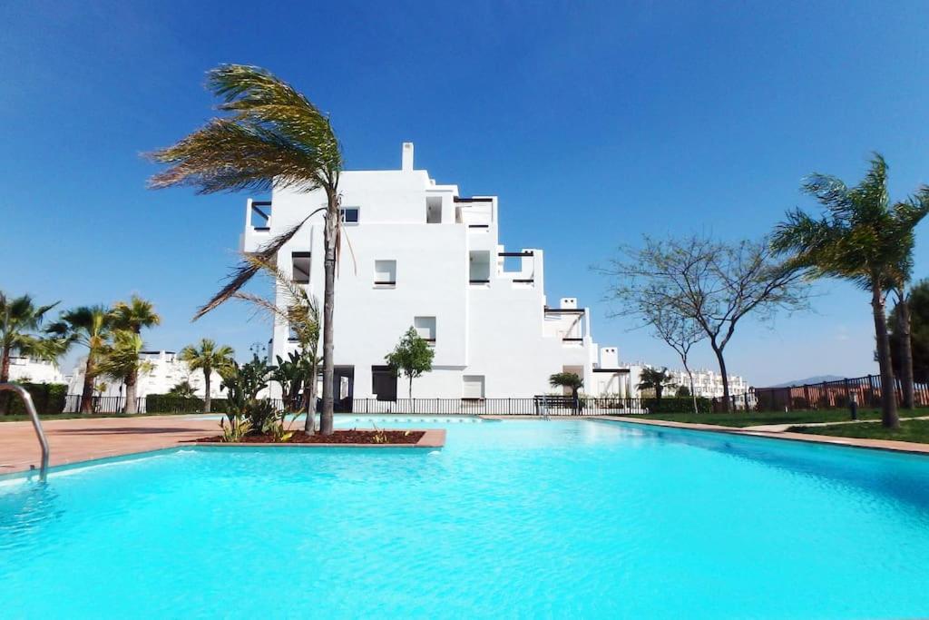 - une piscine en face d'un bâtiment blanc dans l'établissement Het Luxe Penthouse Sunset is PUUR genieten !, à Alhama de Murcia