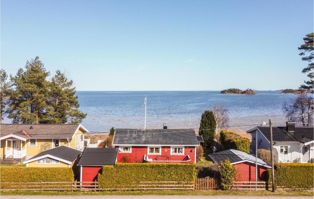 a group of houses with the ocean in the background at Nice Home In Mellerud With 3 Bedrooms in Mellerud