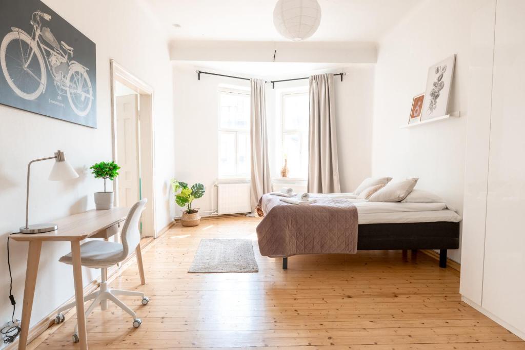 um quarto com uma cama, uma secretária e uma mesa em 2ndhomes 1BR Apartment in the Center of Helsinki em Helsinque