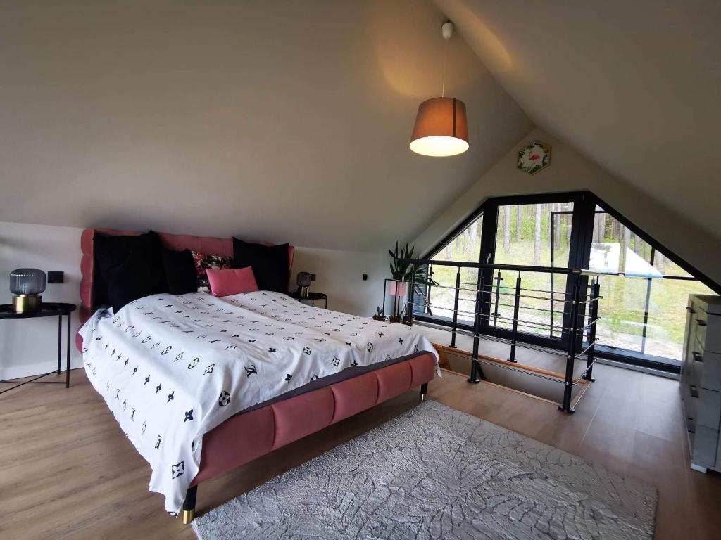 a bedroom with a large bed and a large window at Brama do lasu - Domek Energia in Borków