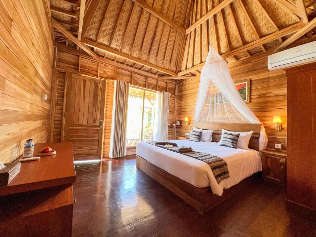 een slaapkamer met een bed in een houten kamer bij Skywatch cottage in Klungkung