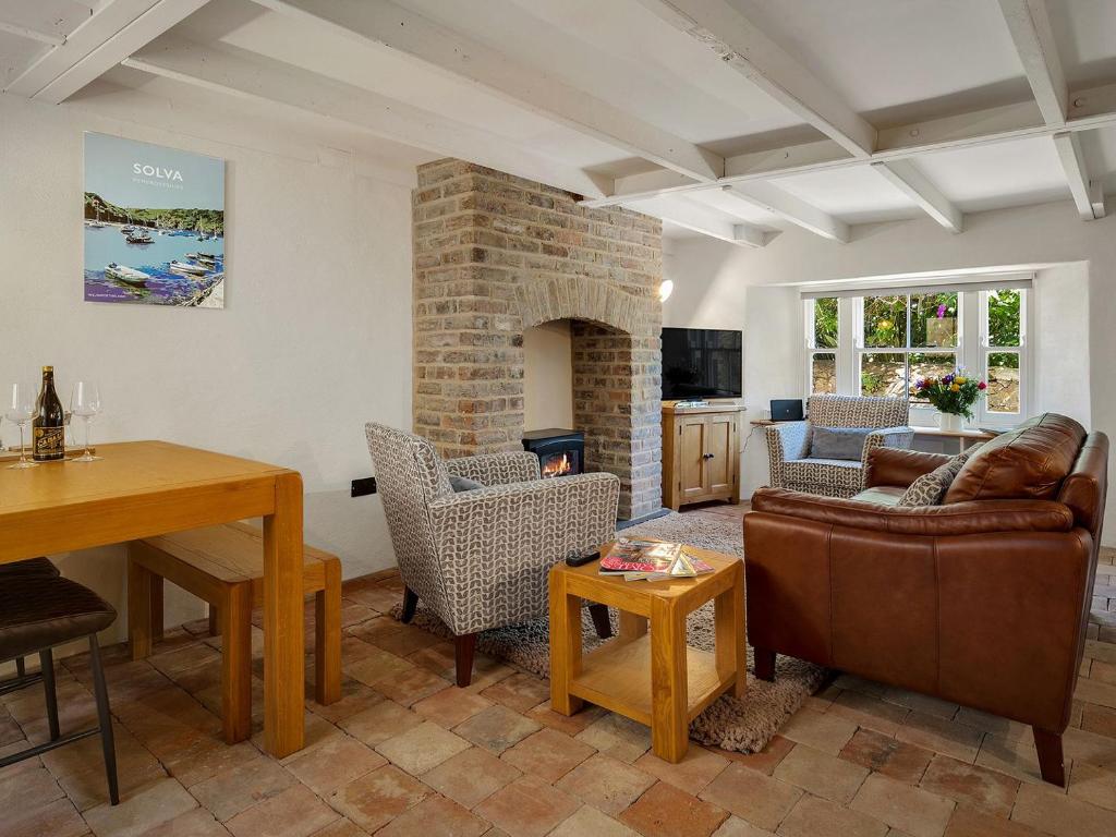 a living room with a couch and a fireplace at Alma Cottage in Solva