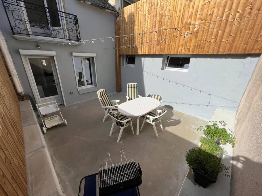 a patio with a table and chairs and a balcony at Maison avec cour privative in Luz-Saint-Sauveur
