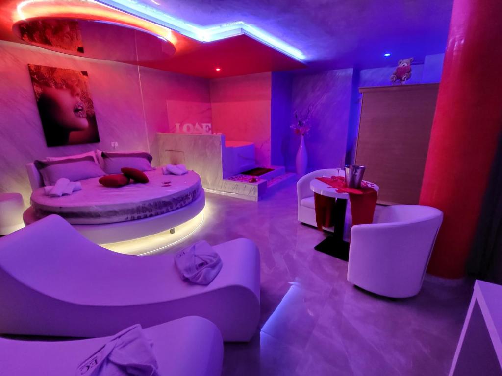 una camera rosa con un letto e sedie di B&B Luxury Room & SPA a Apricena