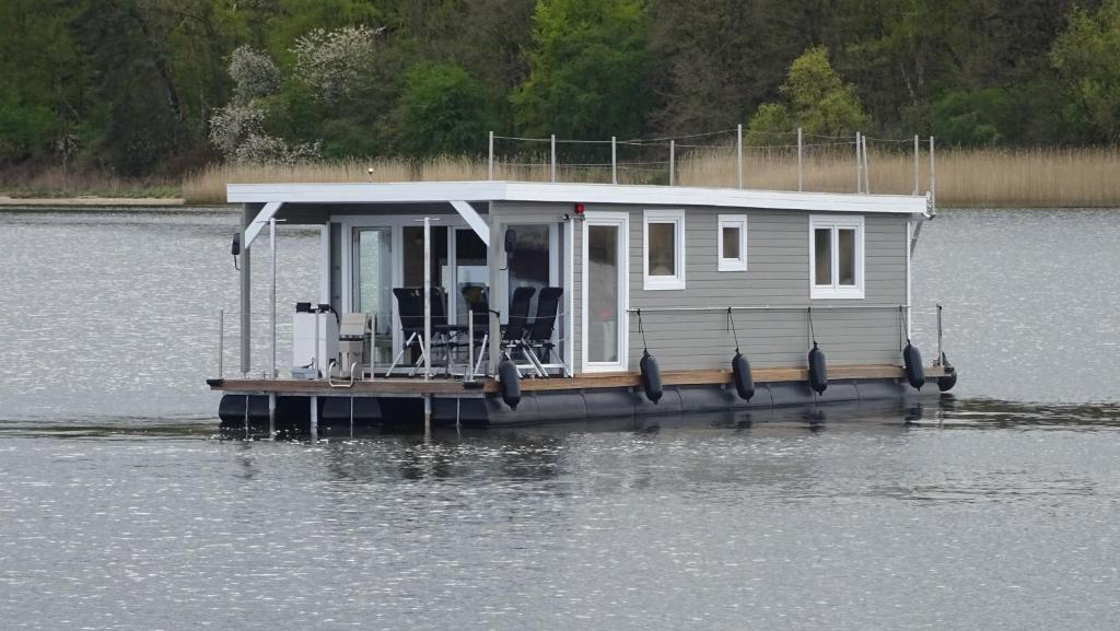 a small house on a dock in the water at Hausboot Janne Lübeck Inclusive Kanu nach Verfügbarkeit SUP und WLAN 50 MBit s Flat in Lübeck