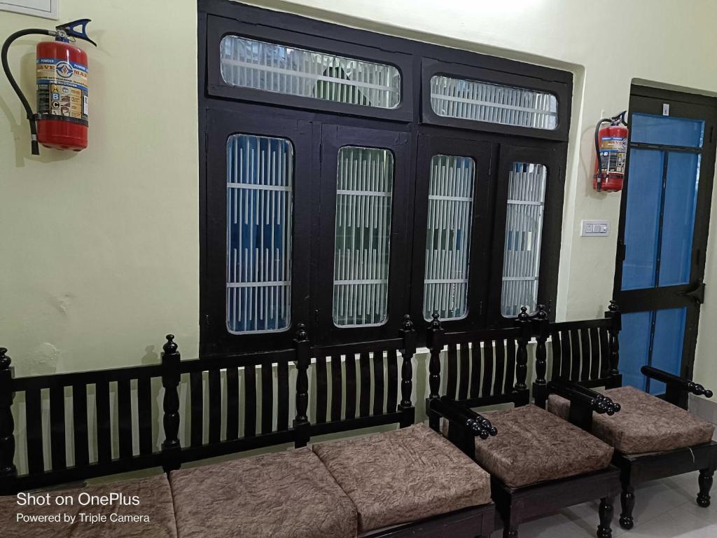 un grupo de bancos en una habitación con ventanas en OYO Home Tawi View Home, en Jammu