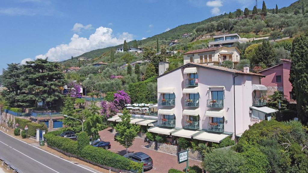 a building on a hill next to a street at Hotel Villa Carlotta in Torri del Benaco