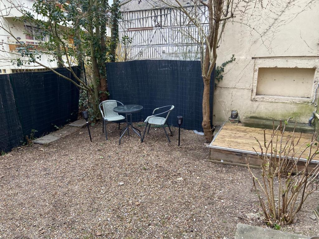 patio con 2 sedie, tavolo e recinzione di Le Duplex a Louviers
