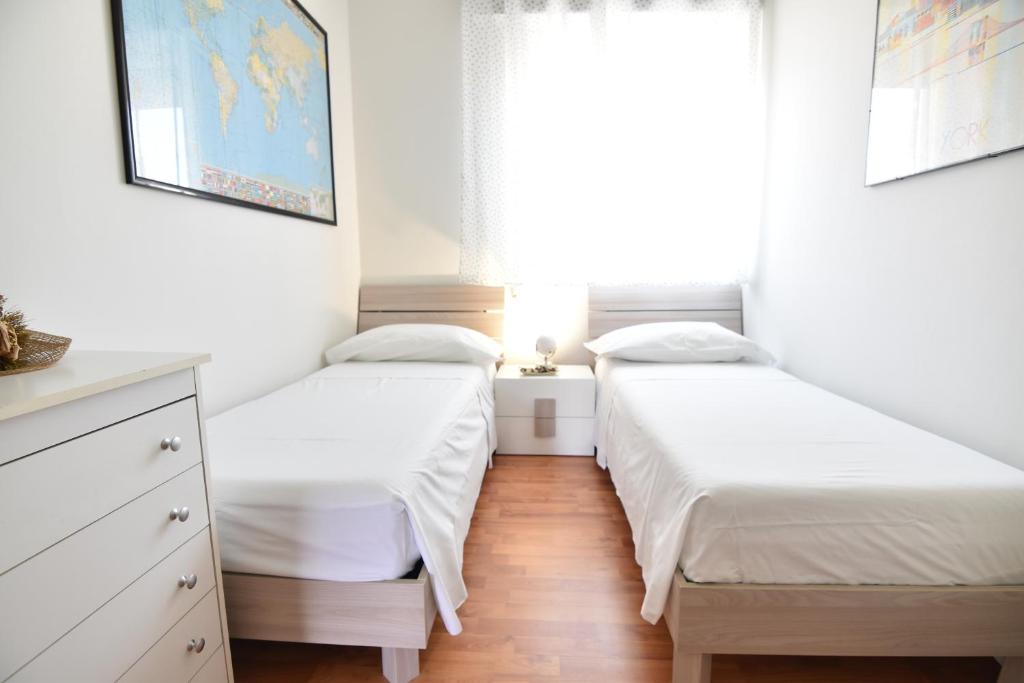 2 camas individuales en un dormitorio con ventana en La Terrazza sul Porto, en Marina di Ragusa