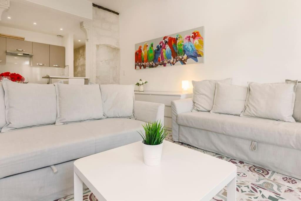 - un salon avec deux canapés blancs et une table dans l'établissement La Loge de l'Horloge - 1 min PALAIS DES PAPES - AC CLIM - WIFI - HYPERCENTRE - vue sur le carrousel, à Avignon