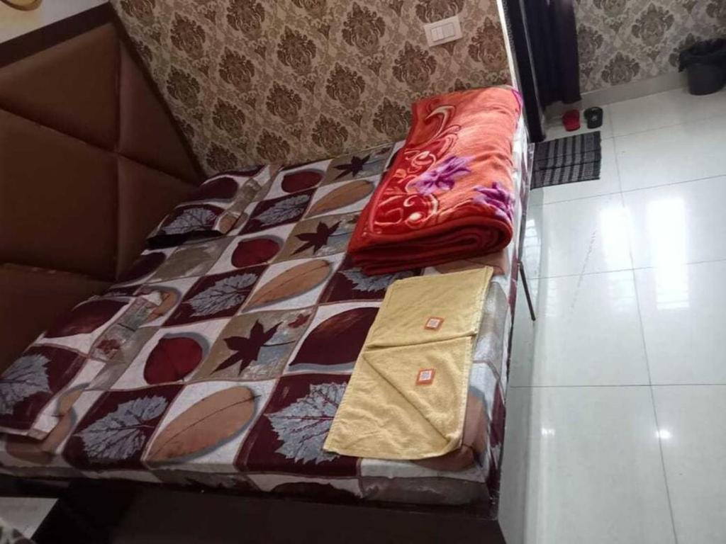 a bed with a comforter on it in a room at Hotel Sunshine in Ludhiana