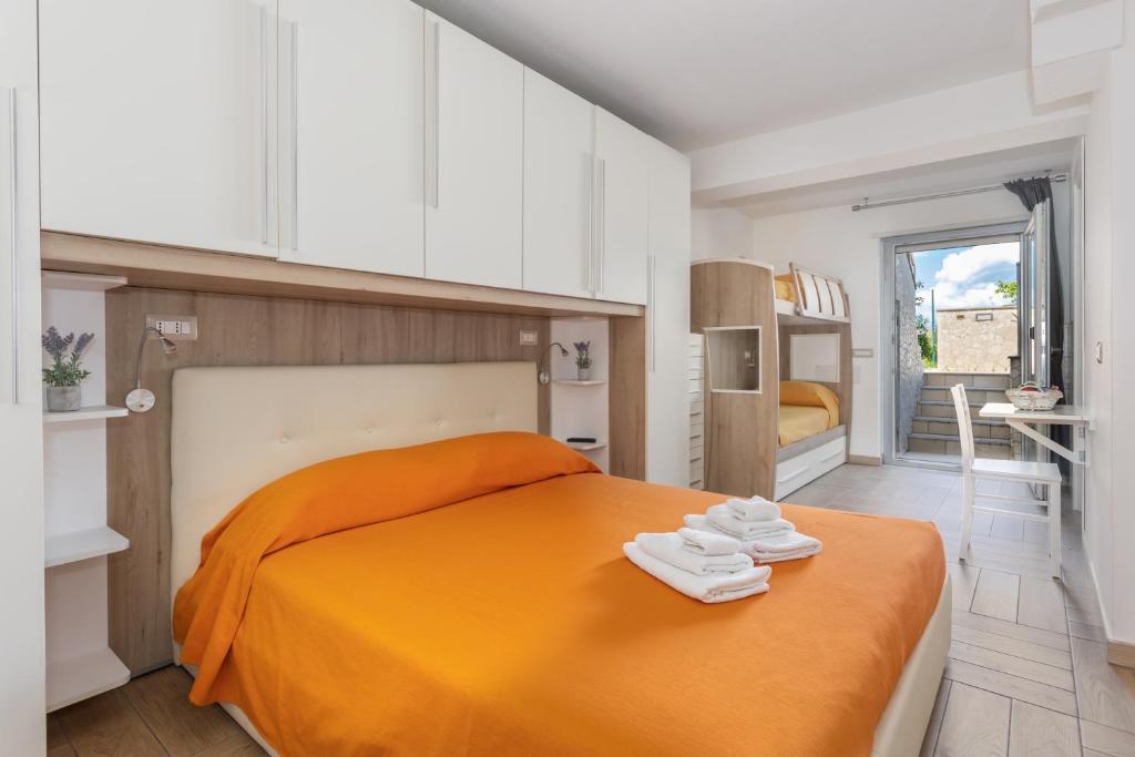 a bedroom with an orange bed with white cabinets at ORISTANO CAMERA ARANCIO max 3pers,BAGNO,USO CUCINA in Oristano