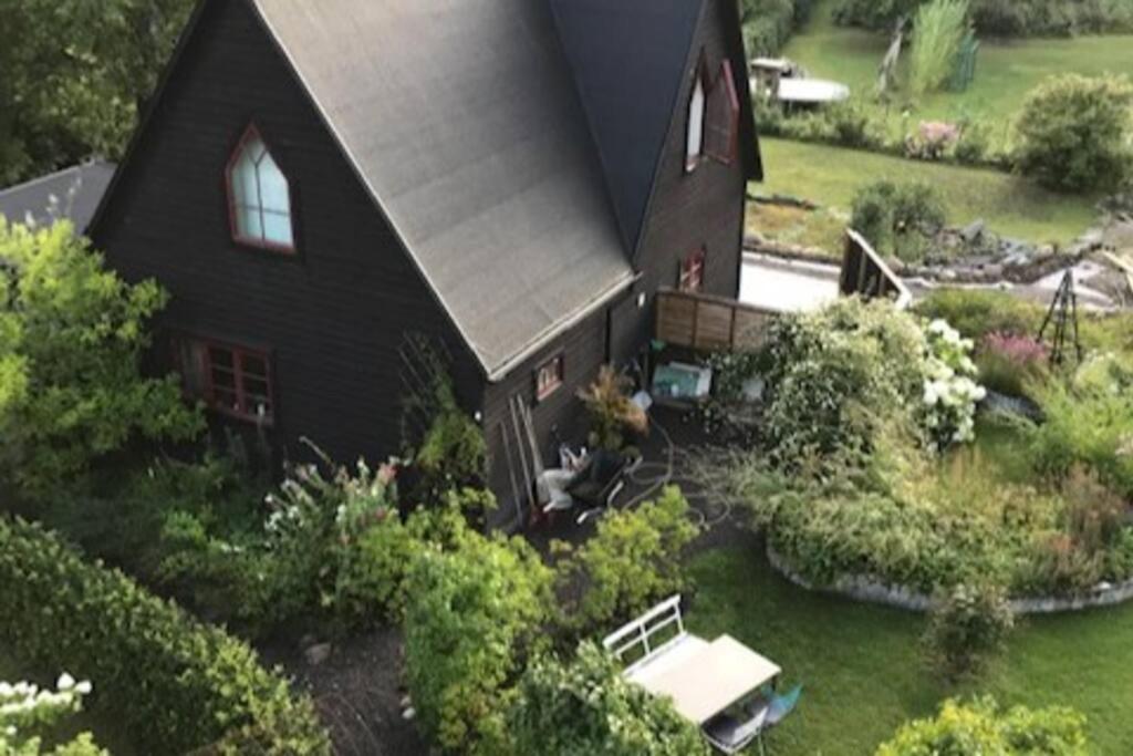 uma vista aérea de uma casa preta com um jardim em Längtan Marielund em Uppsala