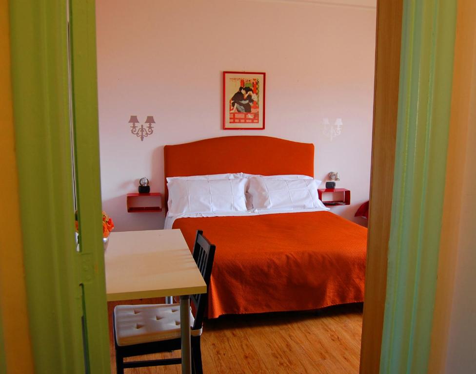 1 dormitorio con 1 cama con manta naranja en Colosseoinn, en Roma