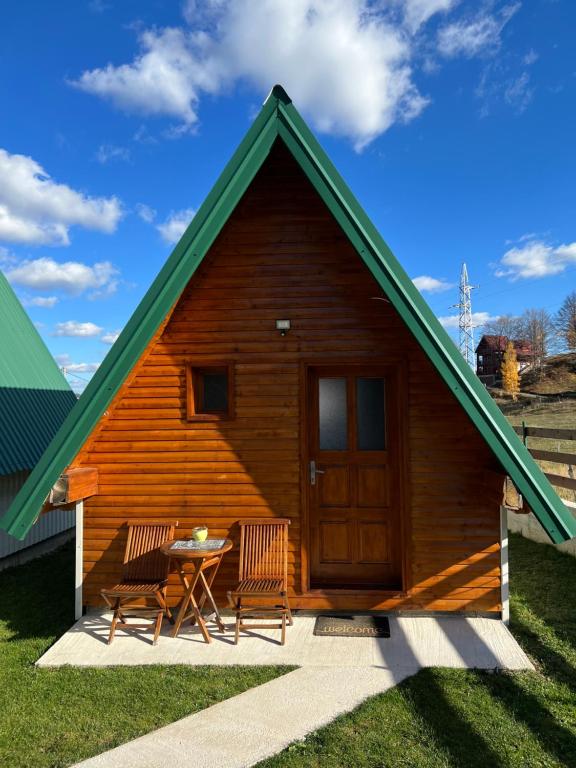 eine kleine Holzhütte mit einem Tisch und 2 Stühlen in der Unterkunft Cottage Danilo in Žabljak