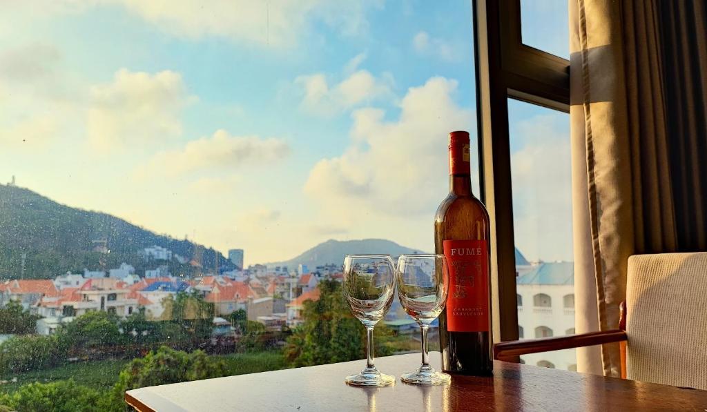 a bottle of wine and two wine glasses on a table at Sun Lake Hotel in Vung Tau