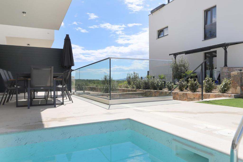 a patio with a swimming pool and a house at Brand new apartment with private pool in Njivice