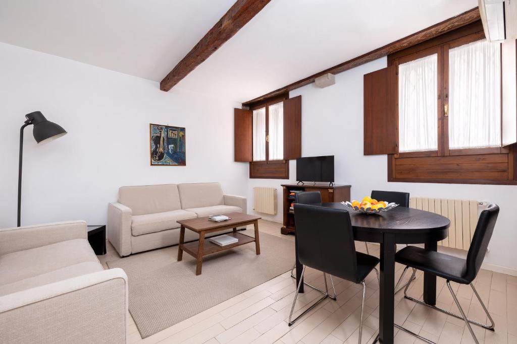 una sala de estar con una mesa y un sofá en Residence Ca&#39; Foscolo, en Venecia