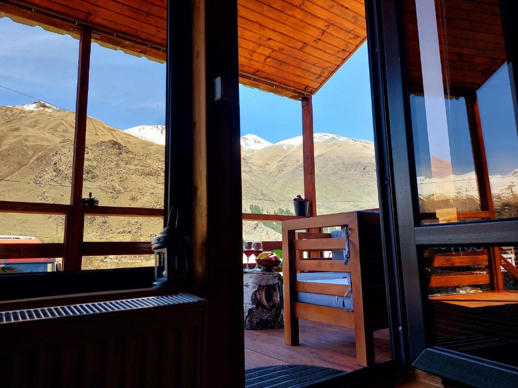 an open door to a room with a view of mountains at Guesthouse and Cottage Nicolo in Kazbegi