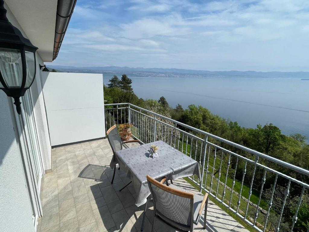 a table on a balcony with a view of the water at Studio Apartman Rubinić in Lovran