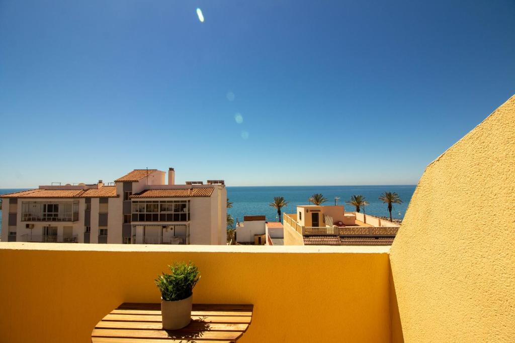 una maceta sentada en la cornisa de un balcón en A view of the beach duplex, en Málaga