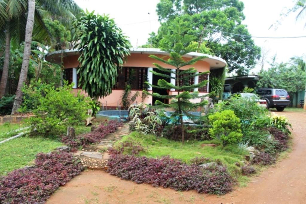 a house with a garden in front of it at Walawe Park View Hotel in Udawalawe