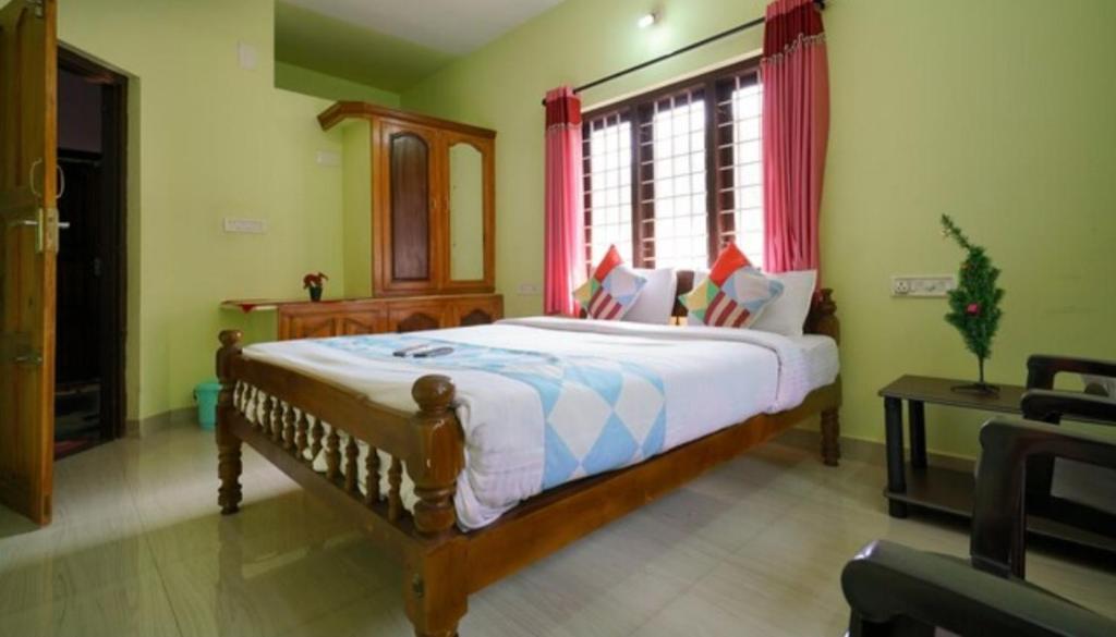 Un dormitorio con una cama grande y una ventana en MUNNAR FALCUNS INN HOMESTAY en Munnar