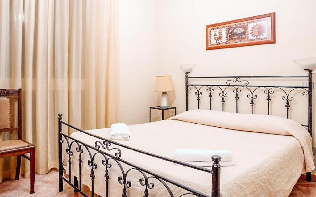 een slaapkamer met een bed met een metalen bedframe bij Terme Country House in Montevago