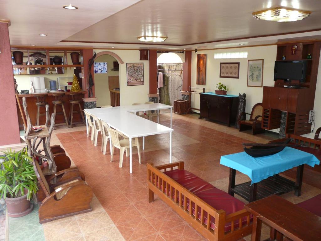 sala de estar con mesa y bancos y cocina en Casa de las Palmeras, en Pansol