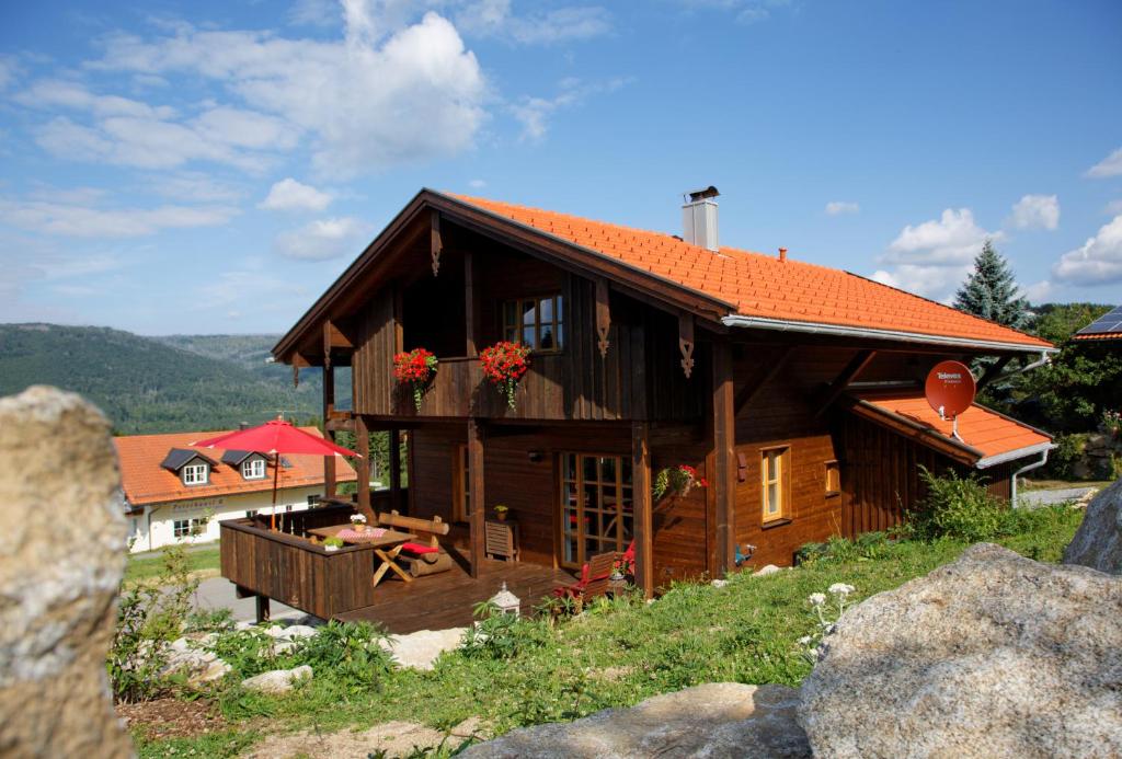 a large wooden house with a red roof at Ferienhaus Hirschkopf in Mauth
