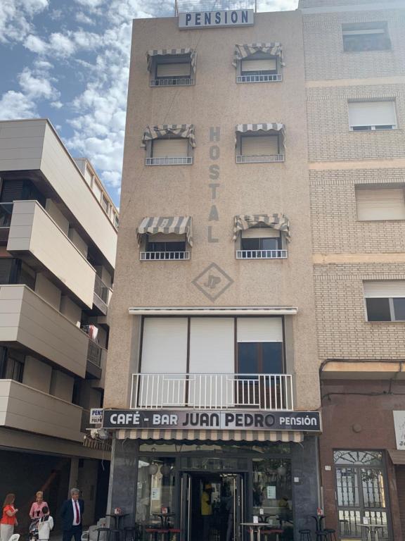 un edificio con un signo de que readsgars bar jumeirah petróleo en Pensión Juan Pedro, en Roquetas de Mar