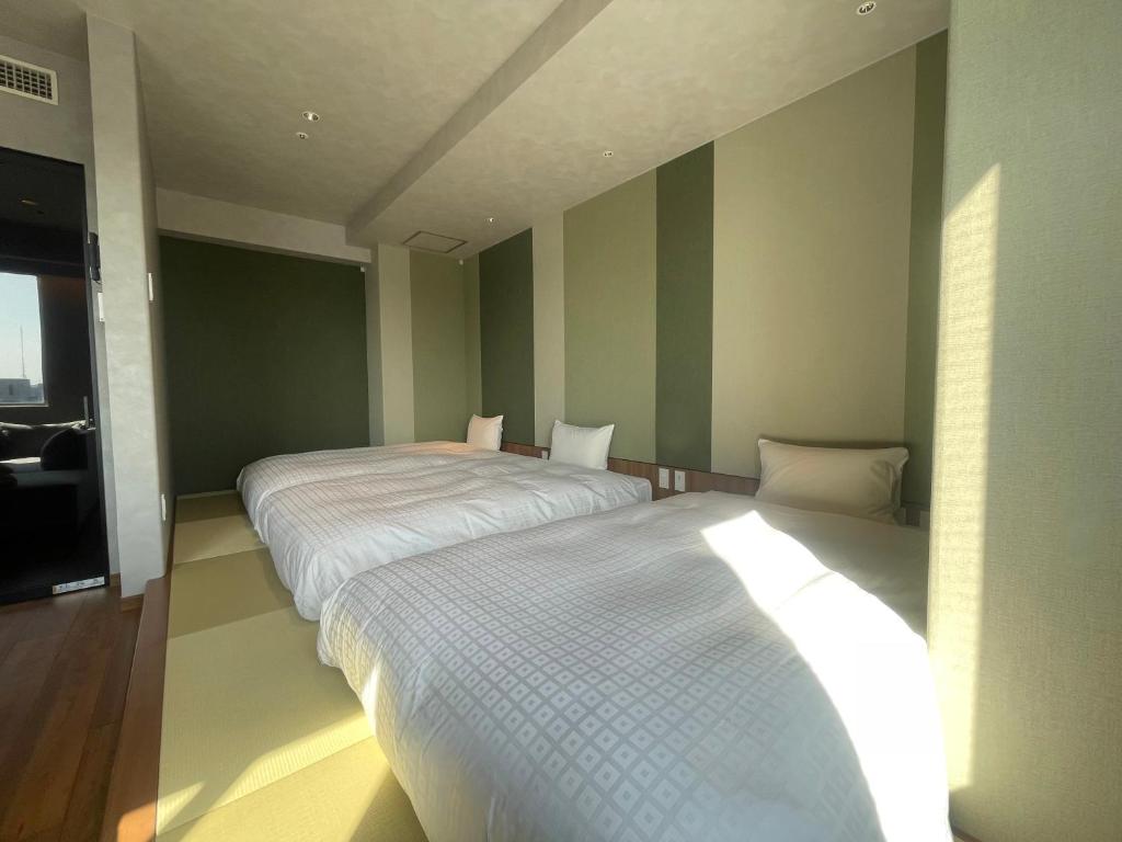 Postel nebo postele na pokoji v ubytování Matsue New Urban Hotel