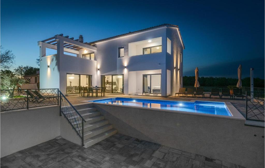 ein großes weißes Haus mit einem Pool in der Unterkunft Cozy Home In Krnica With Kitchen in Krnica