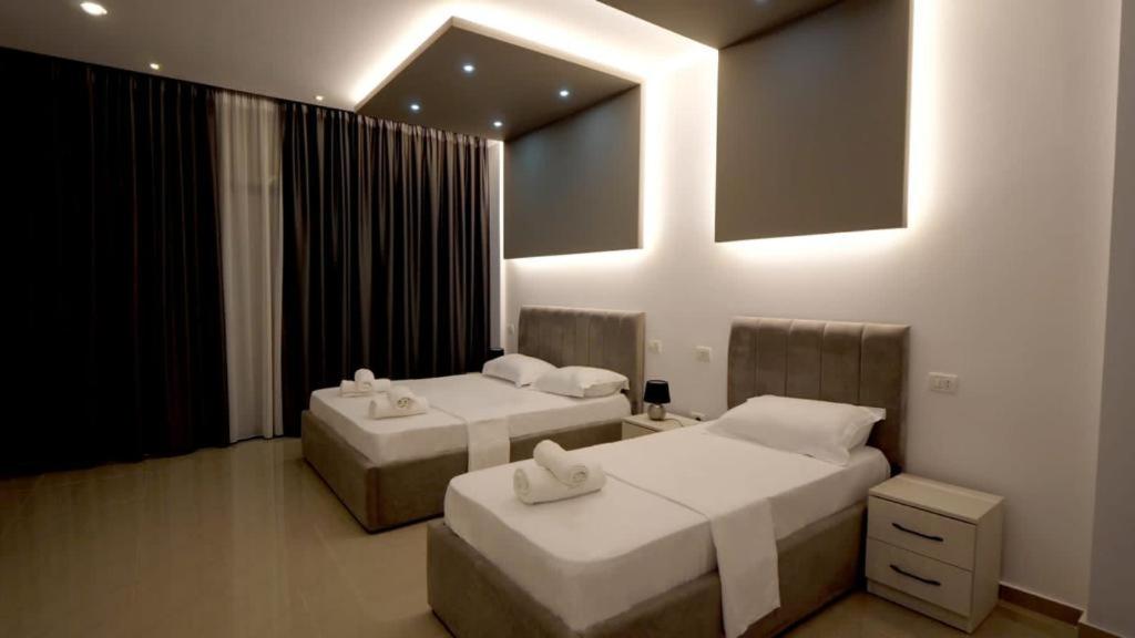 Belsh的住宿－Perla e Dumrese, Bar-Restaurant-Hotel，一间卧室配有两张带毛巾的床