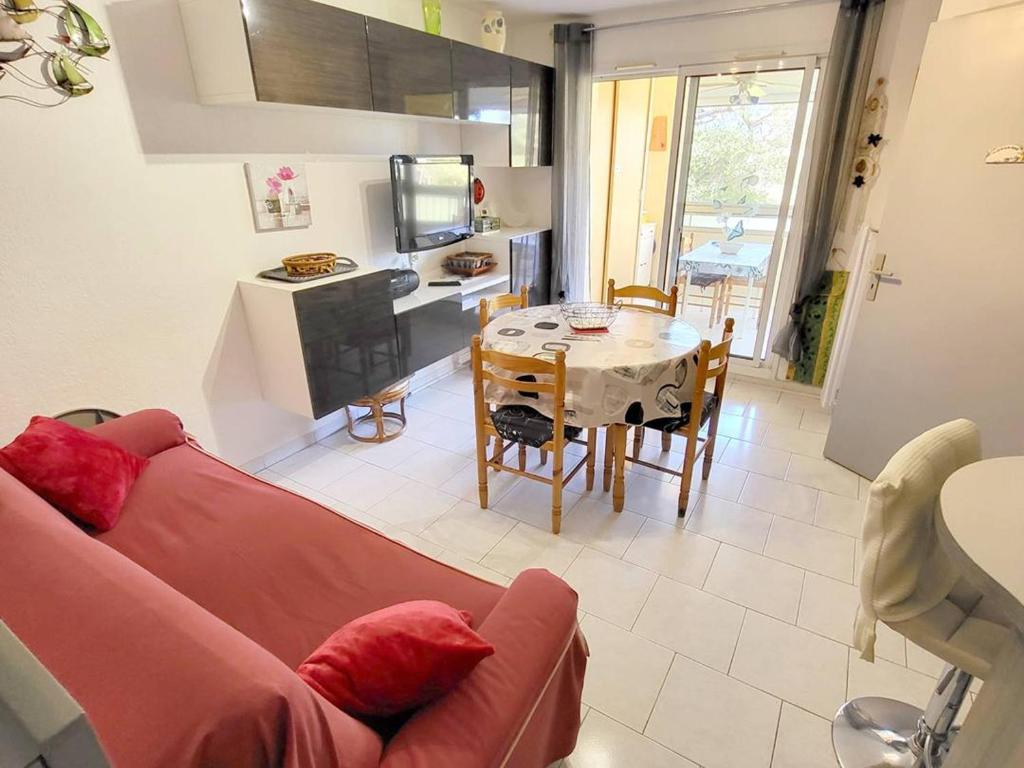 a living room with a red couch and a table at Appartement Six-Fours-les-Plages, 3 pièces, 4 personnes - FR-1-316-50 in Six-Fours-les-Plages