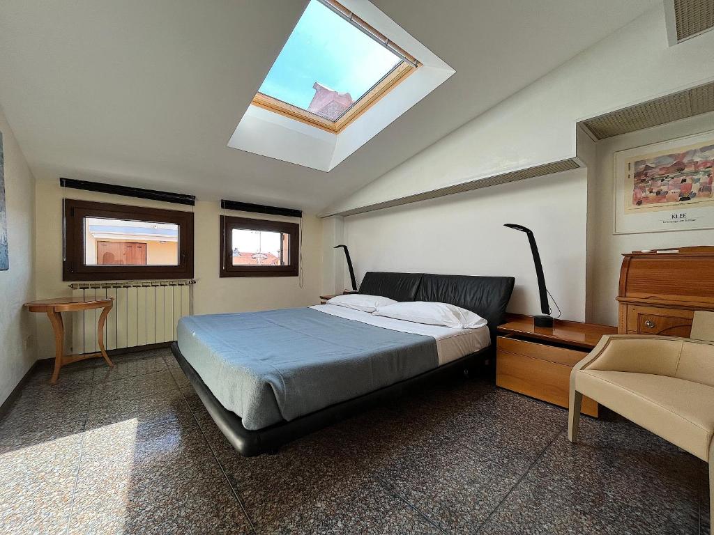 a bedroom with a bed and a skylight at Appartamento Marchesini in Grado