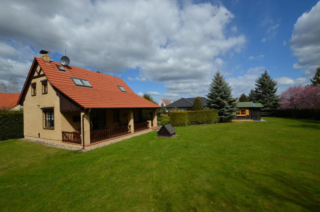 una casa con techo rojo en un patio verde en Dom wakacyjny Jaśki, en Trzcianka