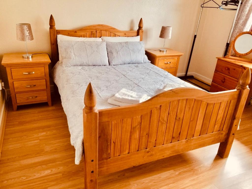 1 dormitorio con 1 cama de madera y 2 mesitas de noche en Inverken House en Inshes