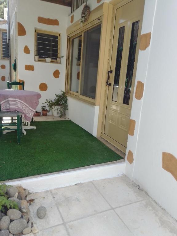 a front door of a house with a green lawn at Fay's House in Mesagrós