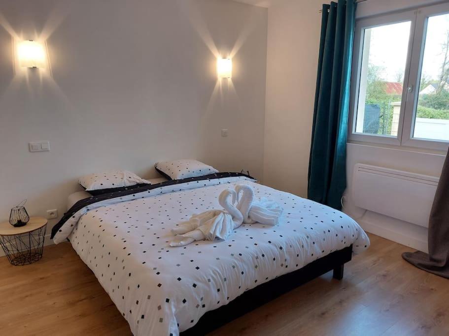 een slaapkamer met een bed met twee handdoeken erop bij Jolie maison entre Terre et Mer in Lithaire