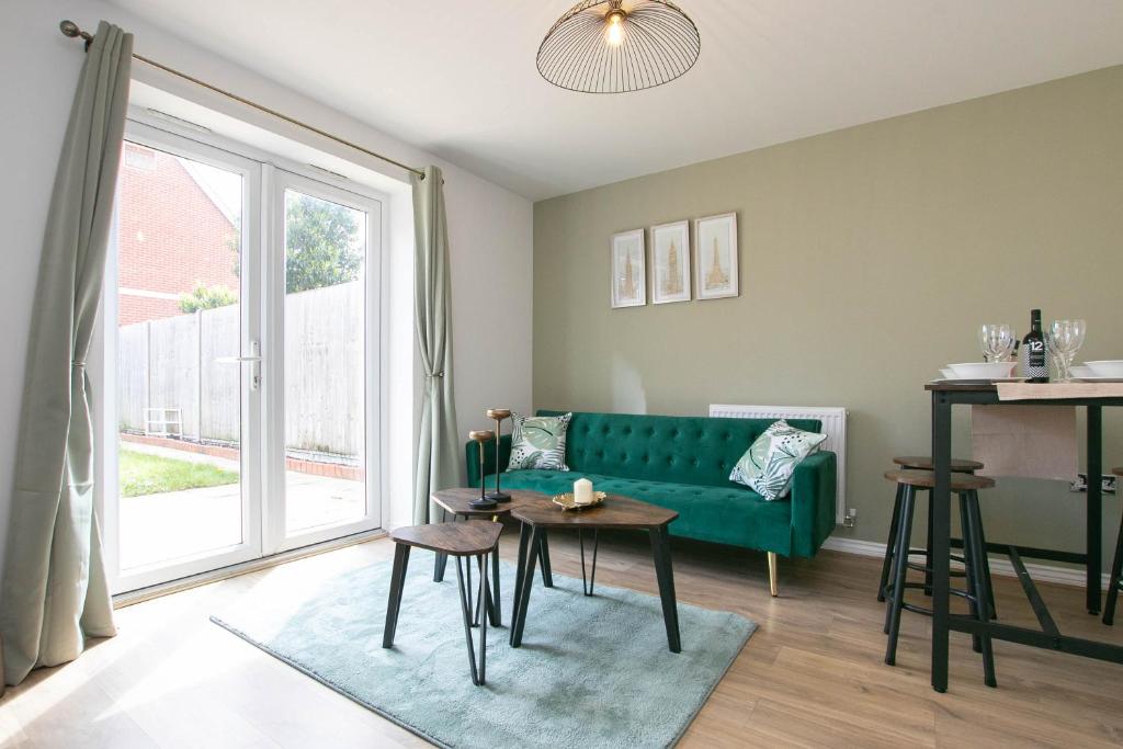 a living room with a green couch and a table at Cozy House in The Heart of Colchester in Colchester