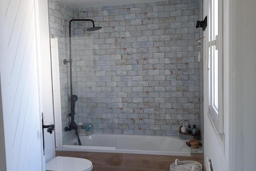 een badkamer met een bad en een toilet bij El Cuartón Tarifa "Sonreír antes de entrar" in Tarifa