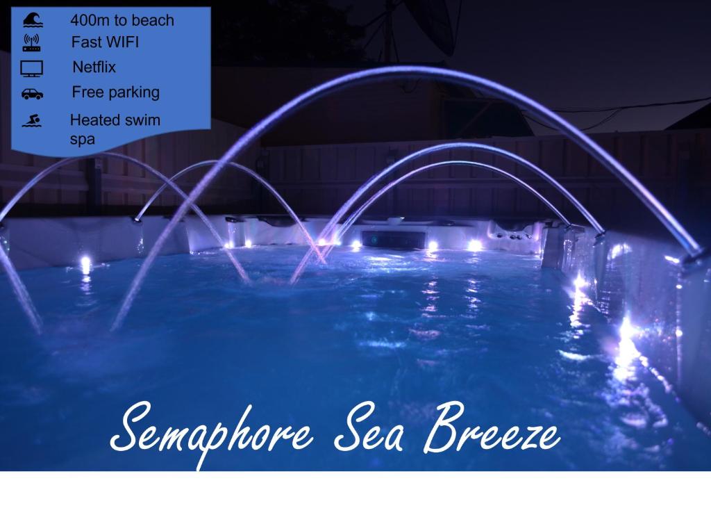 - une piscine avec 2 fontaines la nuit dans l'établissement Semaphore Sea Breeze-Family Beach-Heated Plunge Pool Holiday House 4 brm 2 bath, à Semaphore